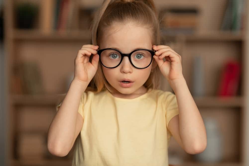 child holding her glasses