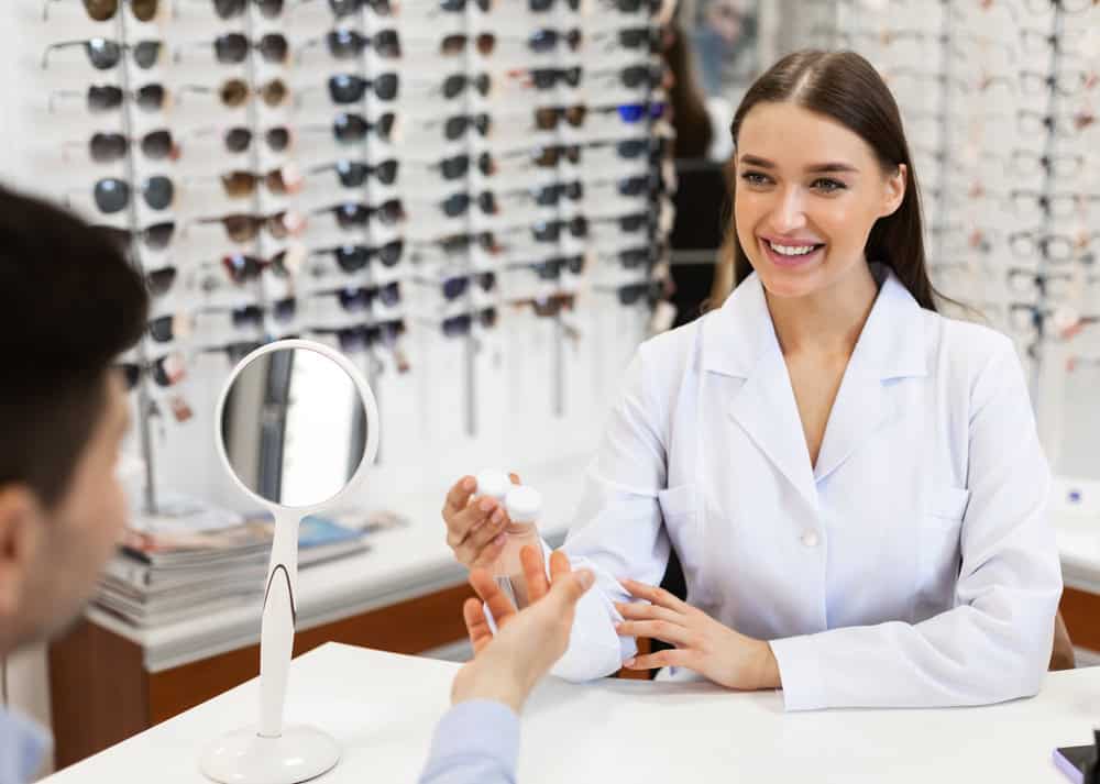 Optometrist giving contact lens to patient